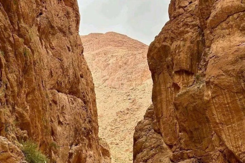 A canyon with rocky cliffs and a distant mountain range. 3