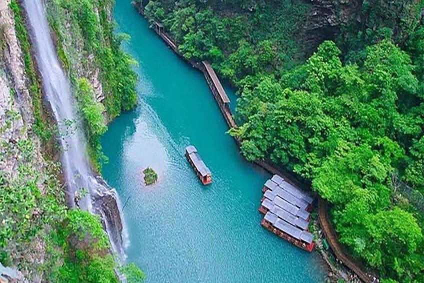 Un río con una barca, un puente y abundante vegetación. 5