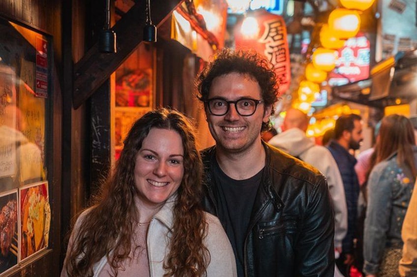 Een drukke straat met verlichte borden en een persoon in een leren jas. 3