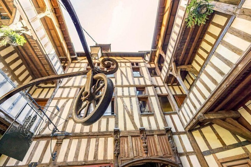 A view of a building with exposed wooden beams and a large wheel structure. 1