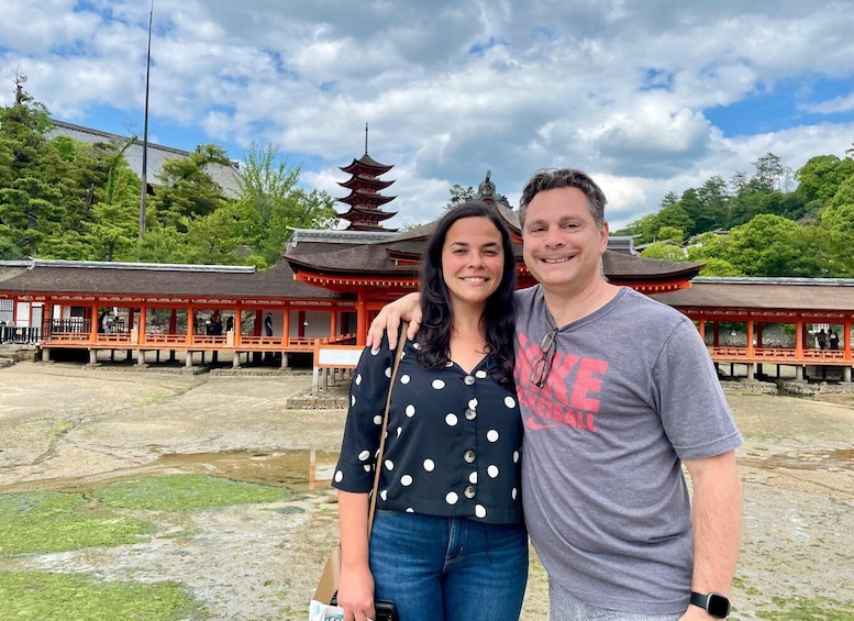 A pagoda with a traditional Japanese roof, a person in a polka dot shirt, and another in a grey t-shirt with a watch. 3