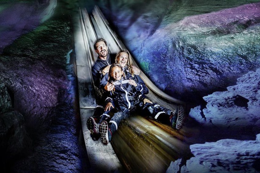 A group of people on a wooden slide in a cave. 2