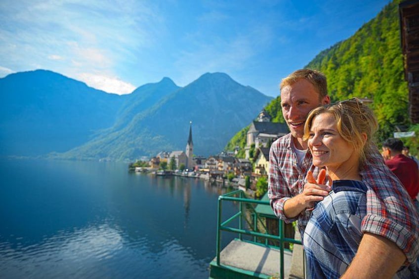 A couple on a boat with a mountainous landscape and a church in the background. 3