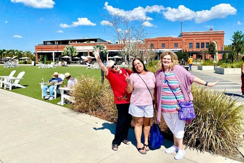 Tres personas posando en una plaza pública con un edificio al fondo. 2