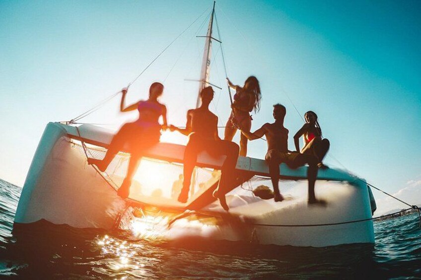 A sailboat with people on deck, water, and a clear sky. 4