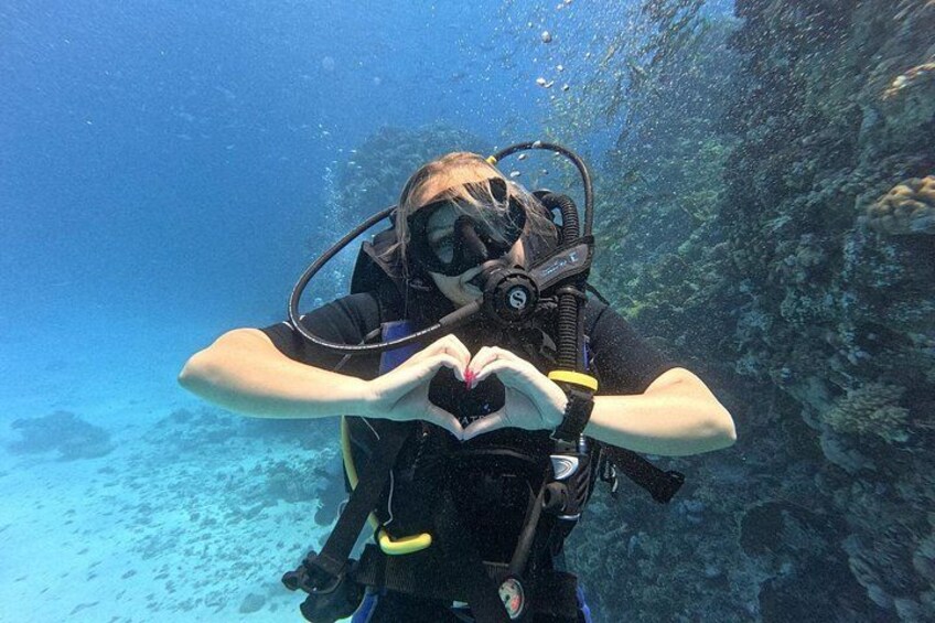 Un buzo bajo el agua formando un corazón con las manos. 1