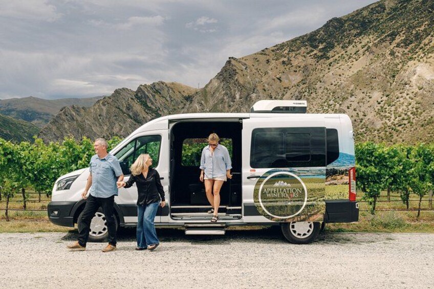 A white van with 'Appellation' branding parked in a vineyard. 3