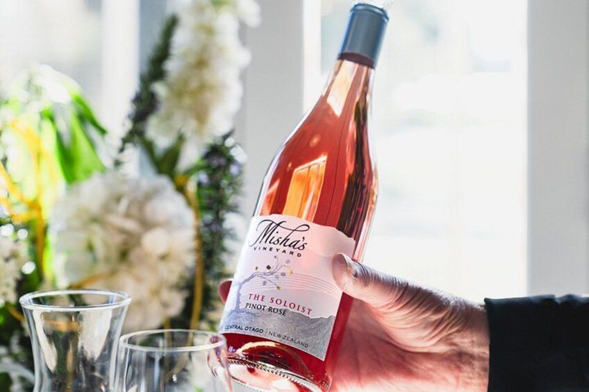 A hand holding a bottle of wine with a label that reads 'Mist's Vineyard Pinot Noir.' 2
