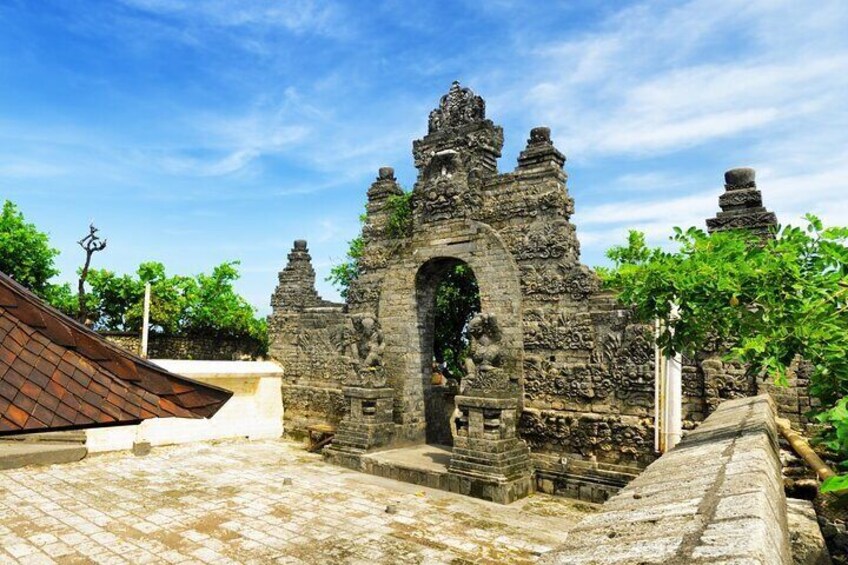 An ancient stone structure with intricate carvings and a central archway. 3