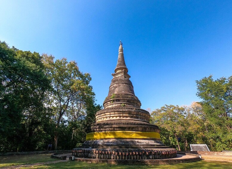 Suuri, useista kerroksista koostuva stupa, jonka ympärillä on puita. 3