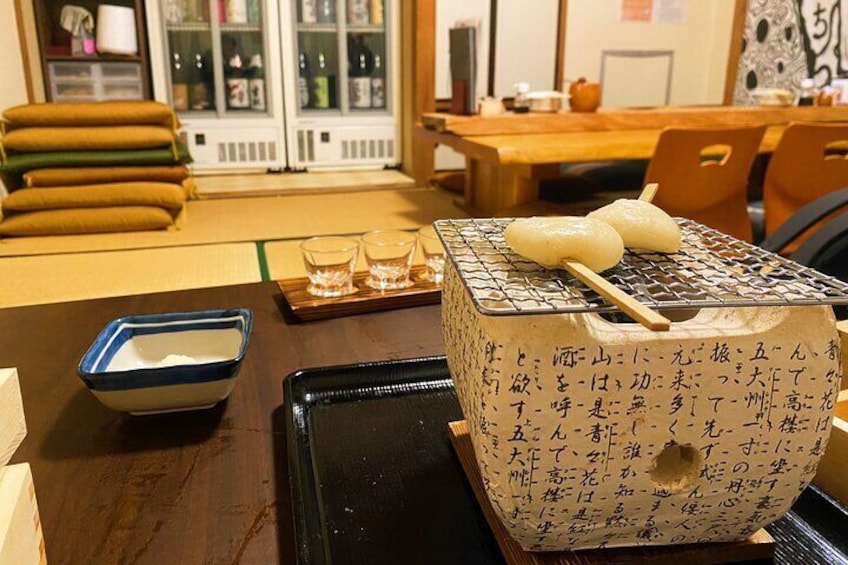 A traditional Japanese meal setup with a tatami mat, a wooden table, and a tatami mat seating area. 5