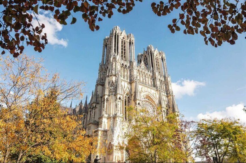 A Gothic cathedral with intricate spires and arches, surrounded by autumn trees. 1