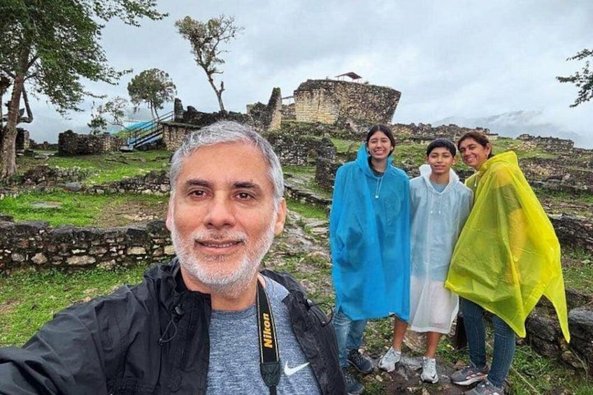 A group of people standing in front of ancient ruins with stone walls and a staircase. 4