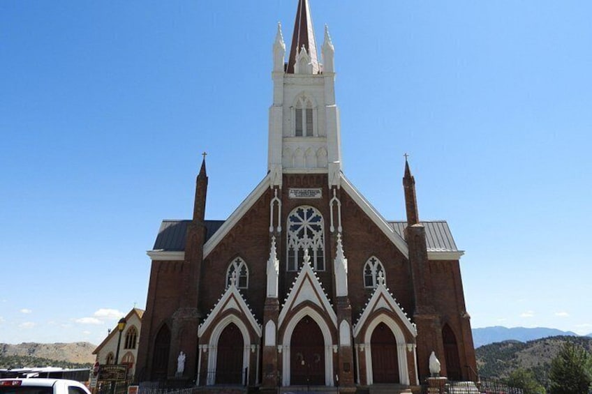 A large brick church with a tall steeple and arched windows. 3
