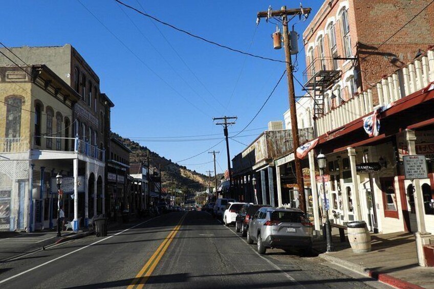 A street with buildings, cars, and a clear sky. 4