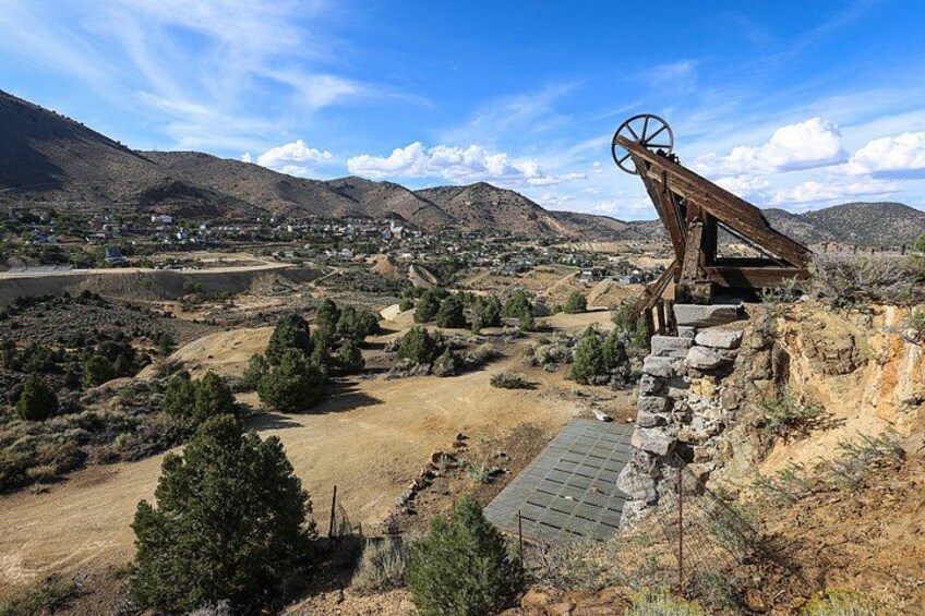 A windmill in a rural landscape with mountains in the background. 2