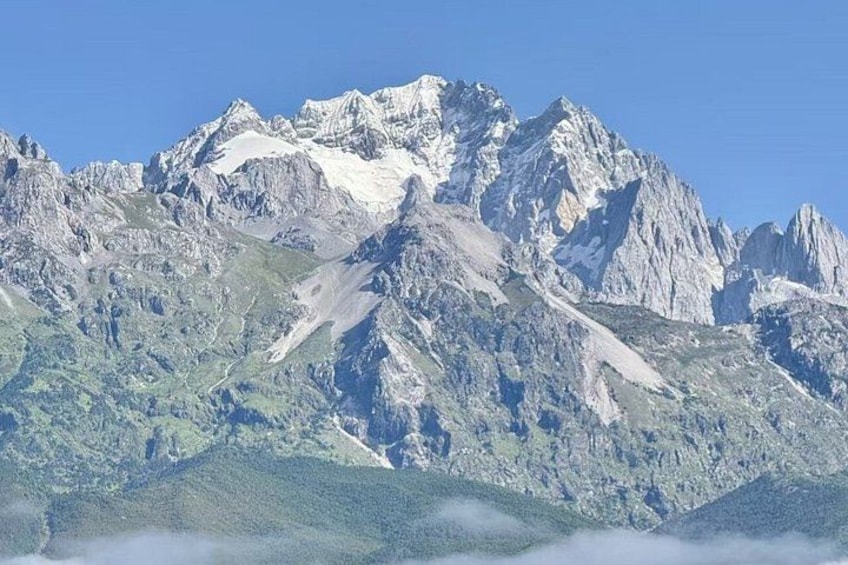 A mountain range with snow-capped peaks and a forested valley. 3