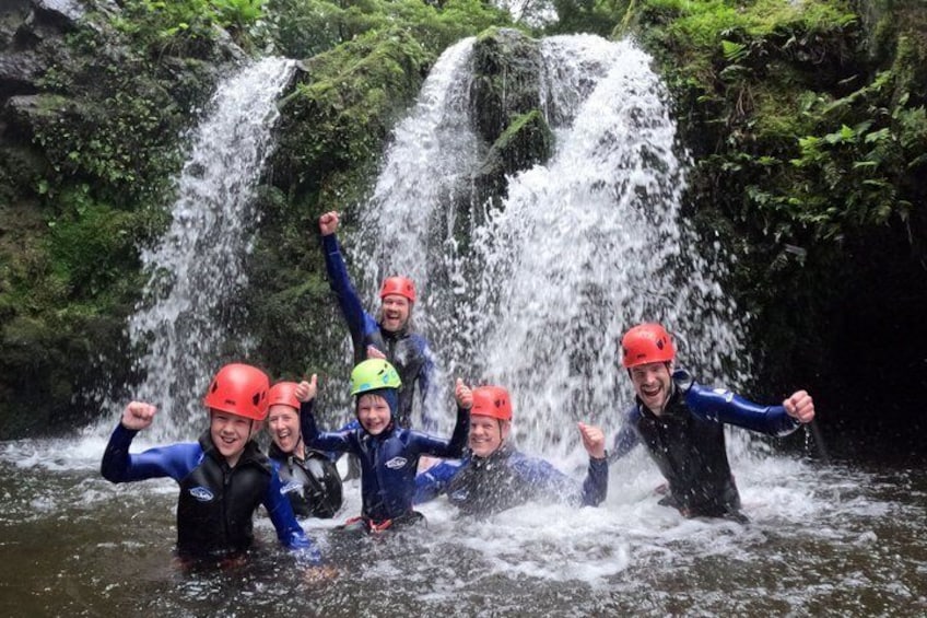 A group of people in waders and helmets at a waterfall. 2