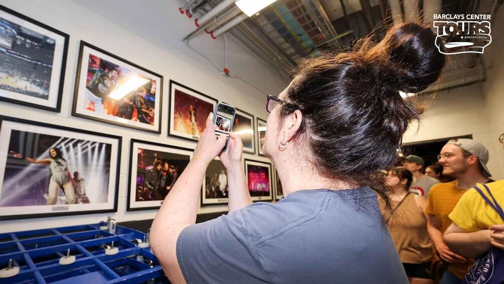 En person som fotograferar inramade bilder på en vägg. 4