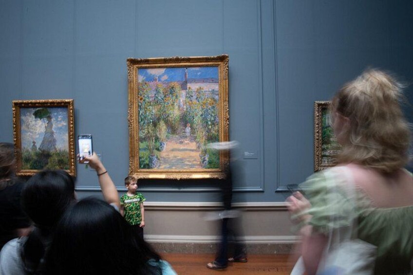 A museum interior with visitors observing paintings. 2