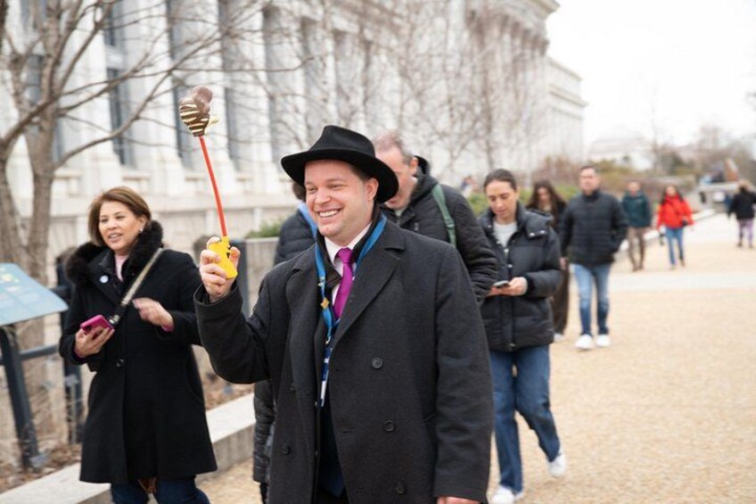 A person in a black coat and hat holding a yellow object. 4