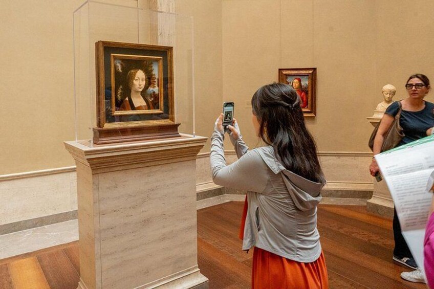 Una persona fotografiando un cuadro en un museo. 2