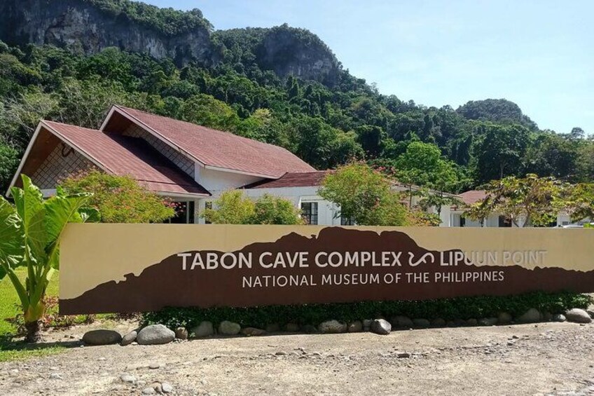 Schild für den Tabon Cave Complex an der Lipuun Spitze, Nationalmuseum der Philippinen, mit einer gebirgigen Kulisse. 5