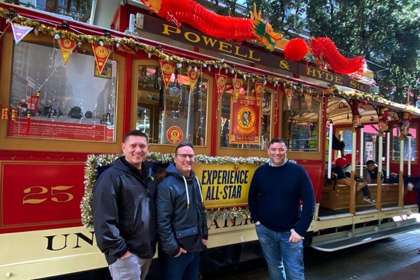 Ein roter und goldener Gepäckwagen mit den Aufschriften 'POWELL & HYDE S' und 'EXPERIENCE ALL-STAR', der Nummer 25 sowie einem festlichen Schmuck. 2