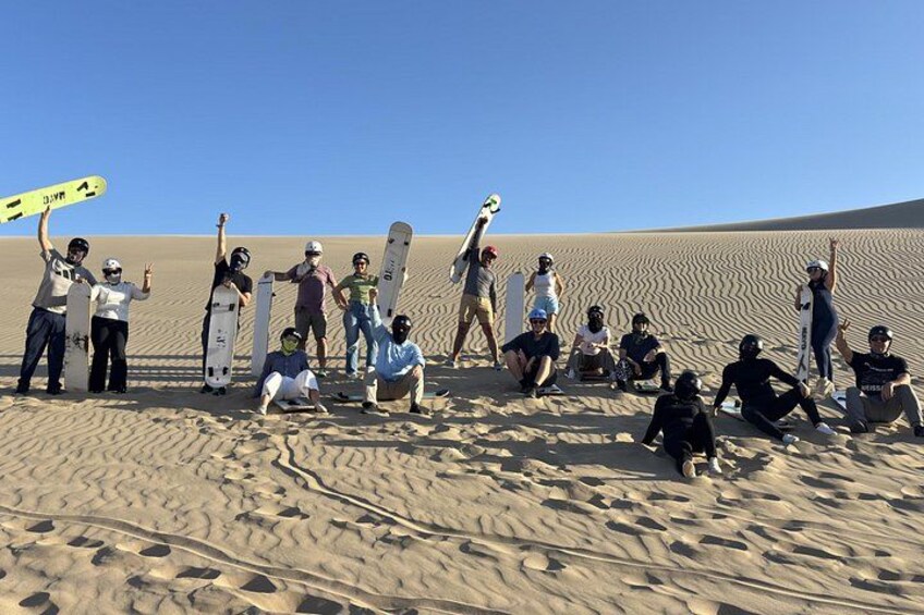 Un gruppo di persone con snowboard su una spiaggia sabbiosa. 2
