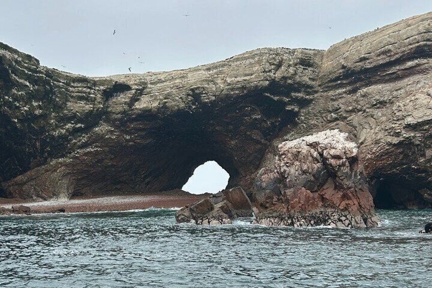 Una costa rocciosa con una grande formazione rocciosa in acqua. 1