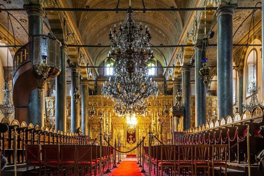 An ornate church interior with a large chandelier, red carpet, and golden altar. 5