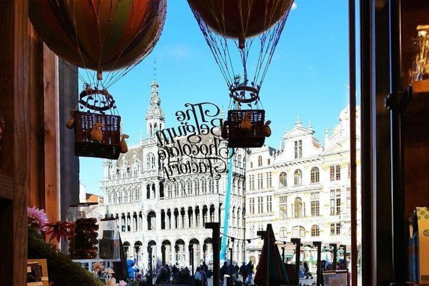 Un edificio histórico con arquitectura ornamentada, un cielo azul despejado y globos aerostáticos en primer plano. 1