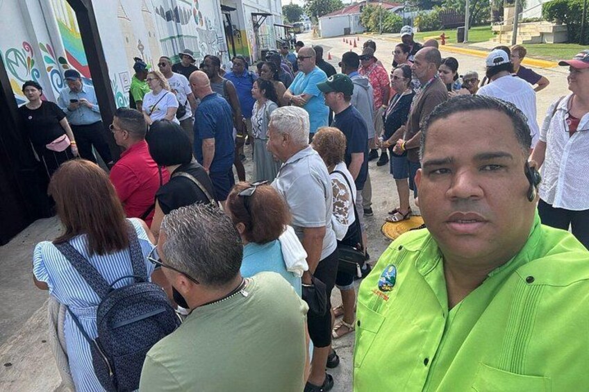 Un grupo de personas hacen fila frente a un edificio con murales coloridos. 2
