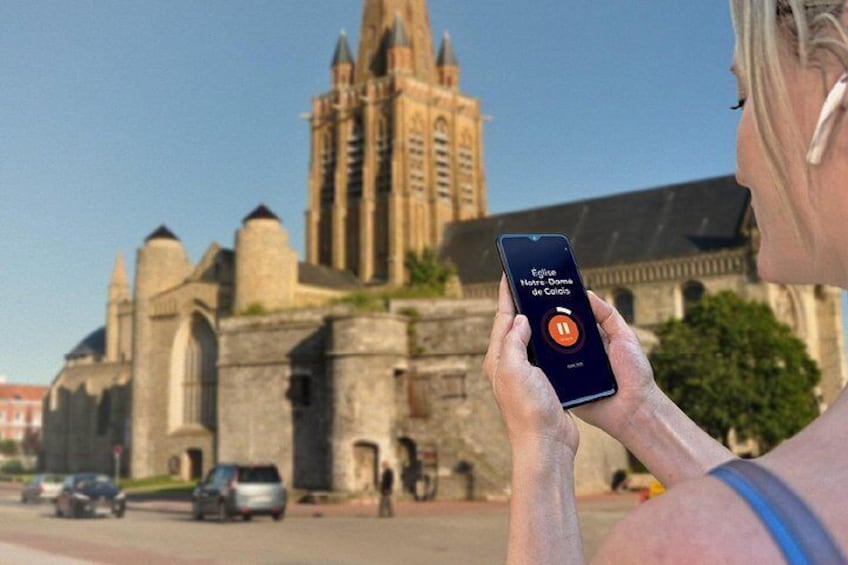 A person holding a smartphone with a map application, a historic cathedral, and a clear sky. 5