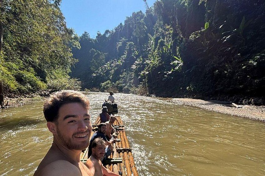 A river with a wooden raft carrying people. 4