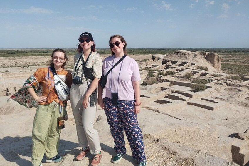 Tres personas frente a unas ruinas antiguas con un paisaje desértico al fondo. 3