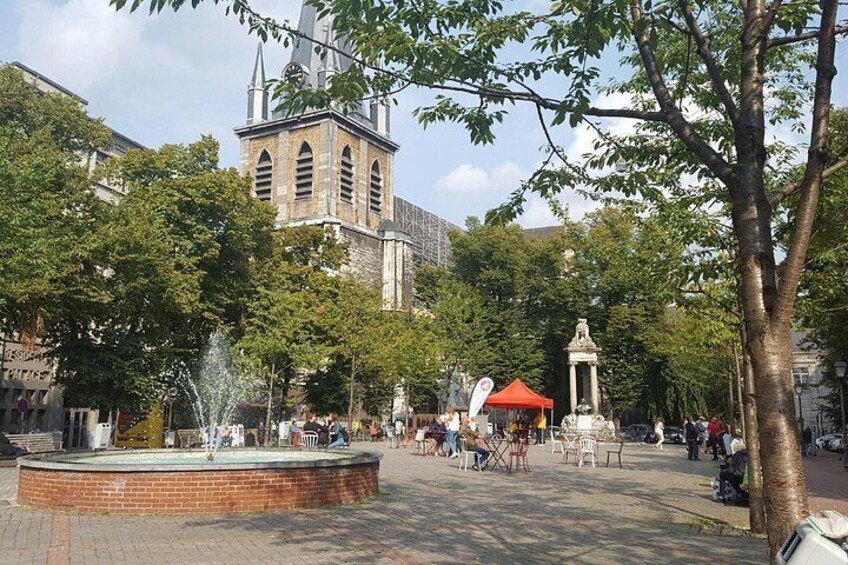 A public square with a fountain, a church, and a red-roofed tent. 2