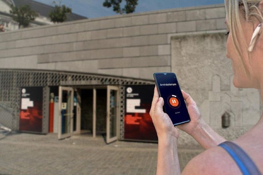 A person holding a smartphone with an app open, standing in front of a building with a sign that reads 'Archipelago.' 4