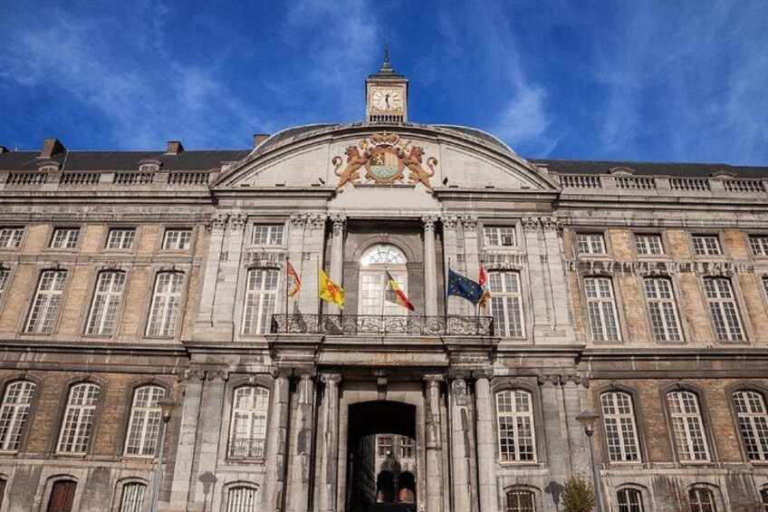 A historic building with a clock tower, flags, and classical architecture. 2