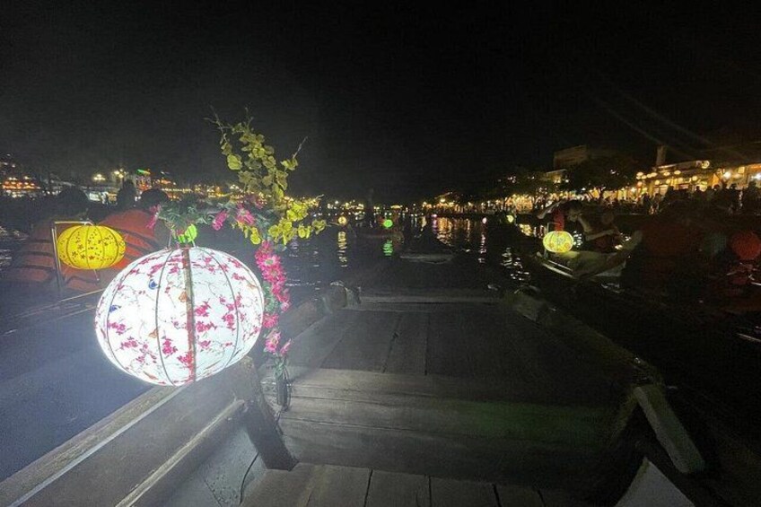 A nighttime scene with illuminated lanterns and a river. 2