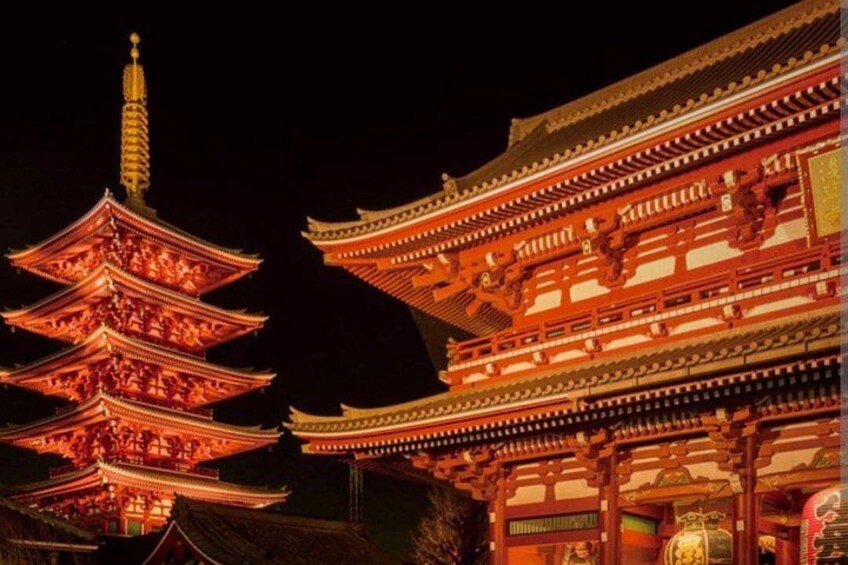 A traditional Japanese pagoda with multiple tiers, illuminated by warm lighting. 2