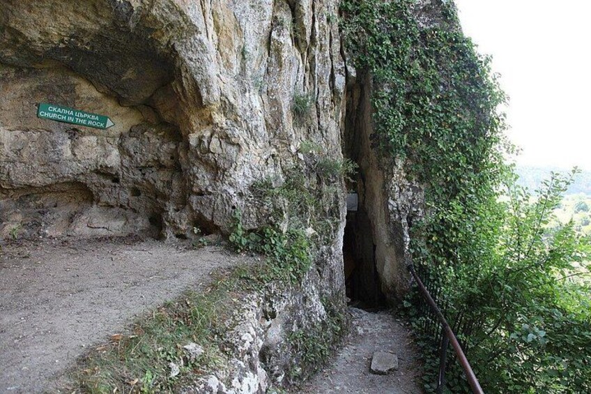 A rocky cliff with a sign indicating a church in the rock. 3