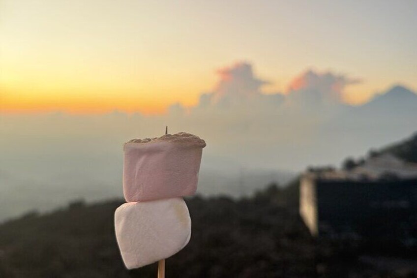 A marshmallow on a stick against a sunset backdrop. 3