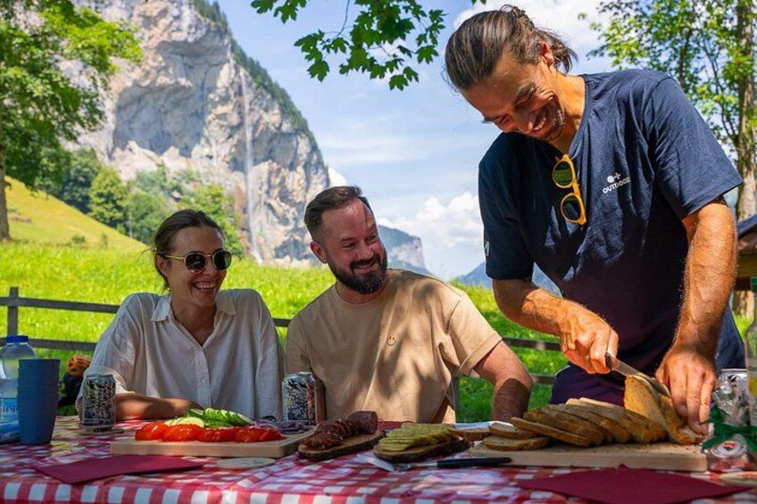 Three people dining outdoors with a mountain backdrop. 3
