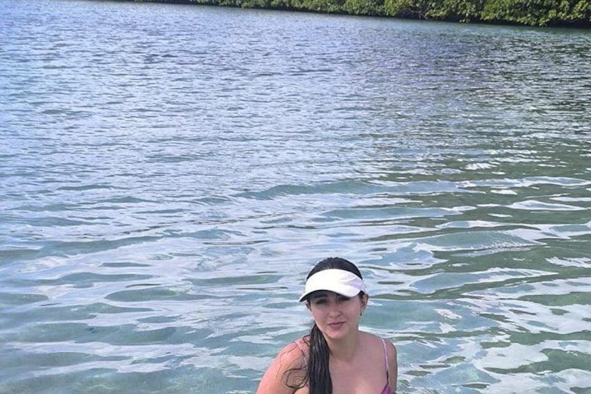 A person in a body of water with a forest in the background. 3