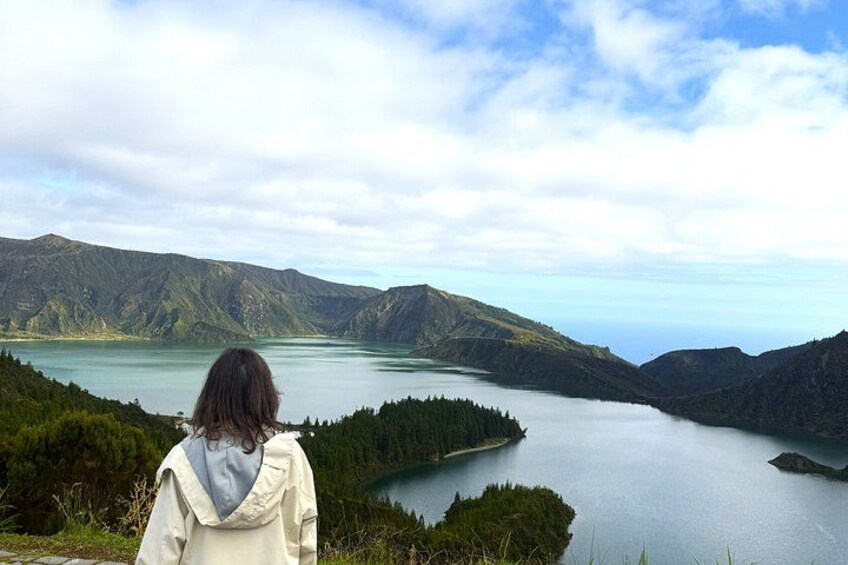 A person overlooking a lake surrounded by mountains. 1