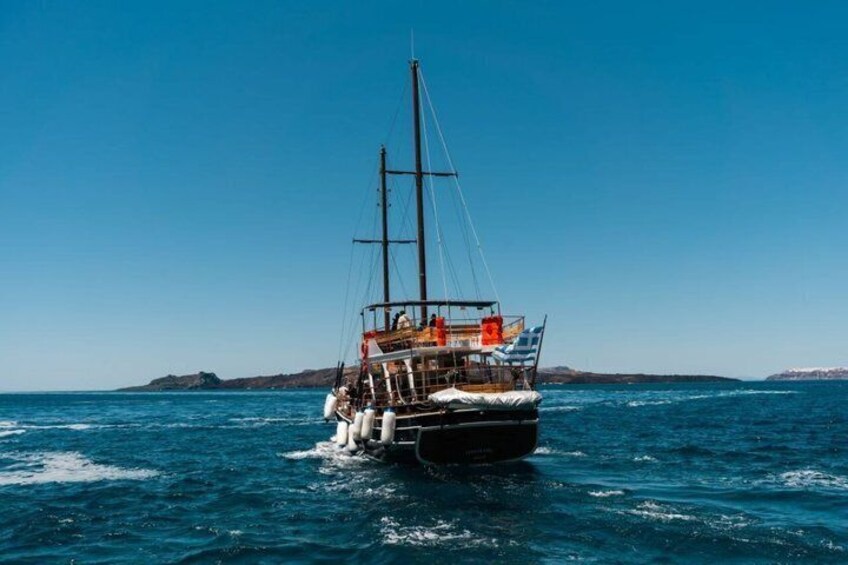 A sailing boat on the ocean with a clear sky and distant land. 5