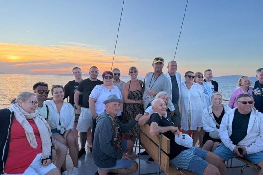 A group of people on a boat at sunset. 3