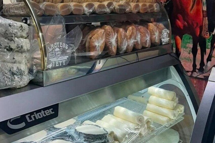 A display case with various baked goods, including bread and pastries, in a bakery setting. 5