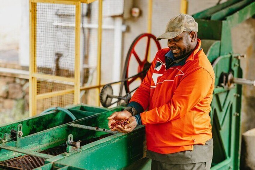 A person in an orange jacket operating a green industrial machine. 5